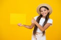 happy teen girl hold empty advertisement paper with copy space on yellow background. thumb up