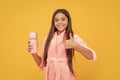 happy teen girl in home terry bathrobe with thermos bottle show thumb up gesture, perfect Royalty Free Stock Photo