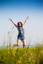 Happy teen girl jumping over blue sky. Beauty girl having fun outdoor Royalty Free Stock Photo