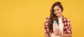 happy teen girl with long curly hair hold shampoo bottle, cosmetic. Banner of child girl hair care, studio poster header