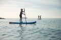 Happy teen girl paddling on sup board in Baltic sea