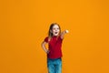 The happy teen girl pointing to you, half length closeup portrait on orange background. Royalty Free Stock Photo