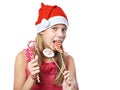 Happy teen girl in red cap eating Christmas cookie isolated Royalty Free Stock Photo