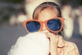 Happy teen girl in sunglasses eating cotton candy in city street Royalty Free Stock Photo