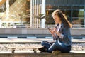 teen girl having a mobile phone sit on a floor in a city Royalty Free Stock Photo