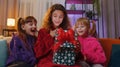 Three siblings children girls opening gift box with excited surprised face, birthday glowing present Royalty Free Stock Photo