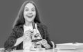 happy teen girl using microscope in high school at blackboard, chemistry Royalty Free Stock Photo