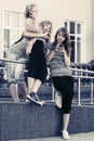 Happy teen girls using cell phones against a school building Royalty Free Stock Photo