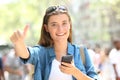 Happy teen holding phone gesturing thumb up