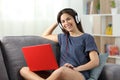 Happy teen with a laptop and headphones looking at camera