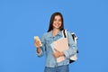 Happy teen Latin girl student holding backpack using phone isolated on blue. Royalty Free Stock Photo