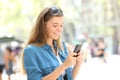 Happy teen messaging on smart phone in the street