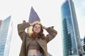 Happy teen redhead girl standing on big city urban street looking at camera. Royalty Free Stock Photo