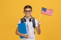 Happy teen schoolboy with notebooks holding usa american flag Royalty Free Stock Photo