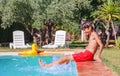 Happy teen splashing in pool on bright sun have fun at resort Royalty Free Stock Photo