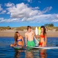 Happy teen surfers talking on beach shore