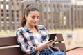 Happy teen using cell phone sitting on a bench Royalty Free Stock Photo