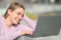 Happy teen using laptop sitting in the street Royalty Free Stock Photo