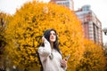 Happy teen woman listening to music and relax in autumn park. Yellow trees, beautiful fall time Royalty Free Stock Photo