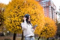 Happy teen woman listening to music and relax in autumn park. Yellow trees, beautiful fall time Royalty Free Stock Photo