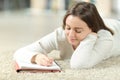 Happy teen writing notes on notebook at home Royalty Free Stock Photo