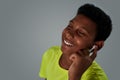 Happy teenage african boy wearing wireless earphones listening to music during workout, keeping eyes closed while Royalty Free Stock Photo