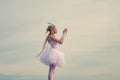 Happy teenage angel girl pray. Child with angelic character. Girl dressed as an angel on a light heaven background