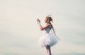 Happy teenage angel girl pray. Child with angelic character. Girl dressed as an angel on a light heaven background