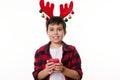 Happy teenage boy with deer antler hoop on his head, holding a lit Christmas candle and smiling a beautiful toothy smile Royalty Free Stock Photo