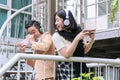 Happy teenage boy and girl in headphones listening to music from smartphone and play video games outdoor. Technology Royalty Free Stock Photo