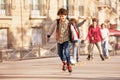 Happy teenage boy roller skating at city side walk Royalty Free Stock Photo