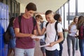 Happy teenage boys sharing exam results in school corridor