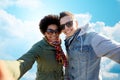 Happy teenage couple taking selfie over blue sky Royalty Free Stock Photo