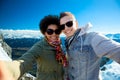 Happy teenage couple taking selfie over mountains Royalty Free Stock Photo