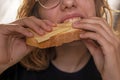 happy teenage girl bites bread with cheese holding Royalty Free Stock Photo