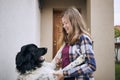 Happy teenage girl coming home and welcoming with her joyful dog
