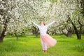 Happy teenage girl dancing in blooming garden with blossom flowers on apple trees Royalty Free Stock Photo