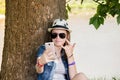 Happy teenage girl with glasses and hat to make selfie