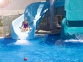 Happy teenage girl going down by water slide into the pool Royalty Free Stock Photo