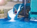 Happy teenage girl going down by water slide into the pool Royalty Free Stock Photo