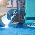 Happy teenage girl going down by water slide into the pool Royalty Free Stock Photo