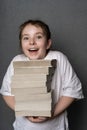 Happy teenage girl holding a big stack of books. Concept of knowledge with pleasure Royalty Free Stock Photo