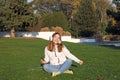 Teenage girl listens to music from her smartphone and sings in park Royalty Free Stock Photo