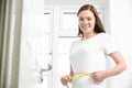 Portrait Of Happy Teenage Girl Measuring Waist In Bathroom Royalty Free Stock Photo