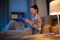 happy teenage girl reading book in bed at home Royalty Free Stock Photo