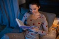 happy teenage girl reading book in bed at home Royalty Free Stock Photo