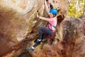 Happy teenage girl rock climbing in forest area