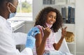 Happy teenage girl showing thumbs up gesture while being immunized against viral infections.