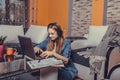 Teenage girl sitting on the floor wearing headphones having a video call online and chatting with her friends with a laptop Royalty Free Stock Photo