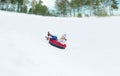 Happy teenage girl sliding down on snow tube Royalty Free Stock Photo